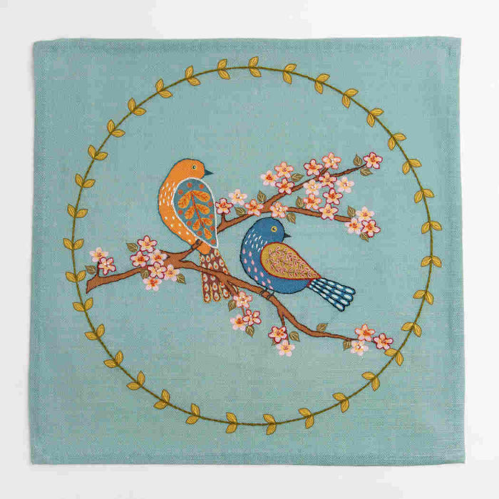 Decorative fabric panel with birds and floral design on a teal background