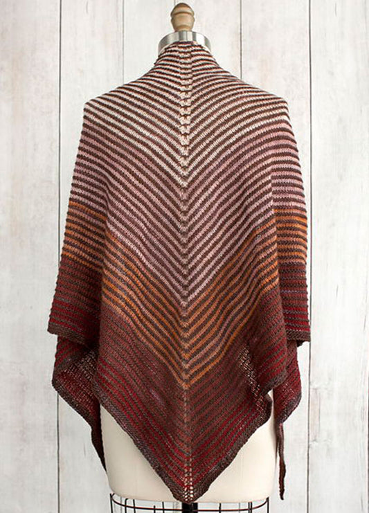 Fino Shadow Shawl on a mannequin, featuring a gradient of brown, orange, and red stripes in a V-shaped pattern, displayed against a wooden background.