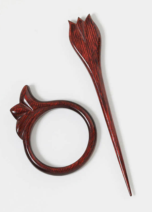 A wooden ring and hair clip made from colorful beech wood, showcasing elegant simplicity for hair and shawl styling.