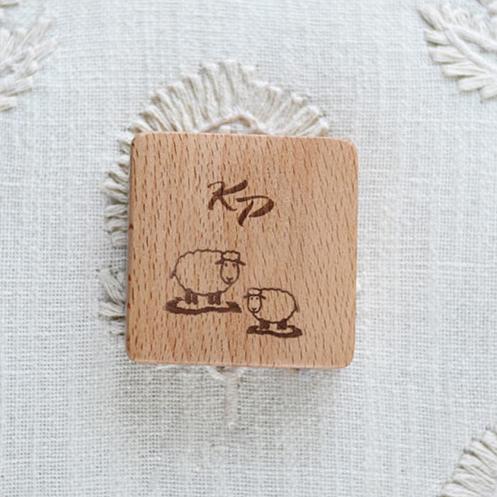 Charming wooden tape measure with a sheep and heart motif, combining contemporary style with everyday utility.