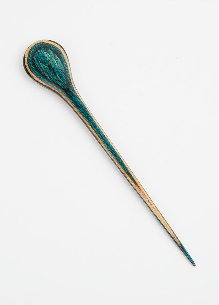A wooden spoon with a teal green handle, highlighting a charming design that enhances both functionality and aesthetics.