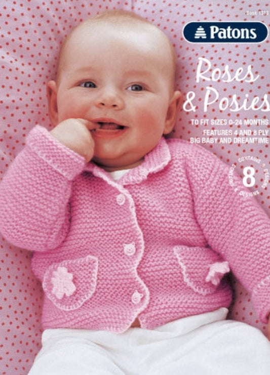Smiling baby in a pink knitted cardigan with flower pockets, lying on a polka dot cushion. Text overlay reads "Patons Roses & Posies."