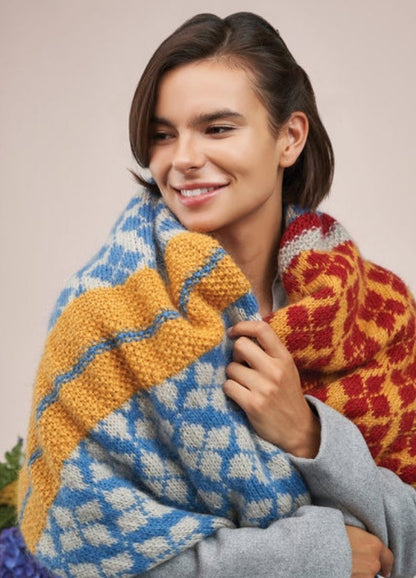 A woman models a stylish knitted scarf, highlighting its intricate design and vibrant color.