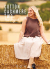 Woman with long blonde hair smiles while sitting on a hay bale, wearing a brown knit top and white skirt. Background shows a blurry pastoral setting.