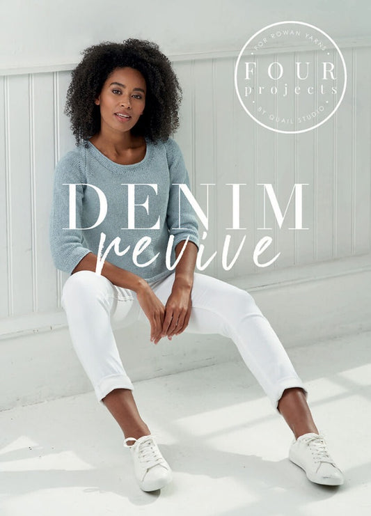 Woman in a soft blue sweater and white pants sits casually on the floor against a light wall. "Denim Revive" text overlay conveys a relaxed vibe.