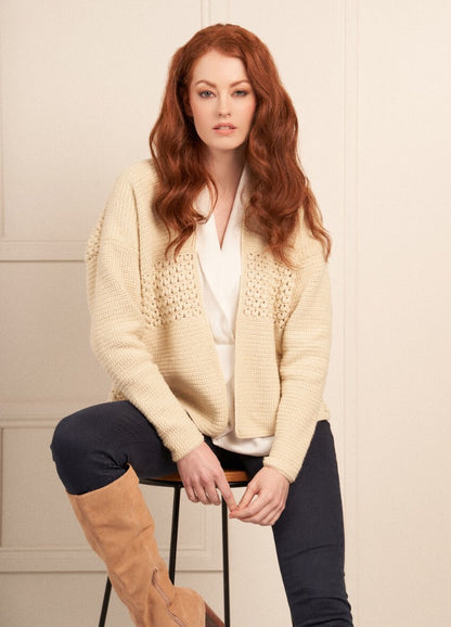 A woman in a cozy, textured knit sweater and stylish boots, showcasing a warm and fashionable autumn look.