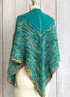 Allspice Shawl draped on a mannequin, featuring a vibrant V-shaped design in teal, orange, yellow, and blue with a curved edge and central spine.