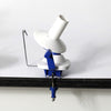 A white and blue hand-operated yarn winder on a table, featuring a clamp for secure use and compact design for easy storage.