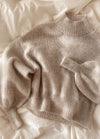 Soft beige Balloon Sweater in fuzzy knit with oversized fit and tapered cuffs, styled with jeans.