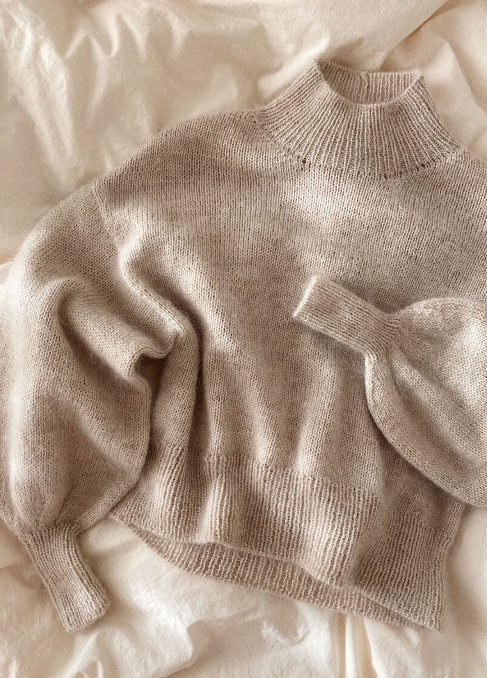 Soft beige Balloon Sweater in fuzzy knit with oversized fit and tapered cuffs, styled with jeans.