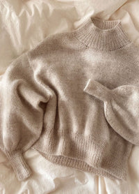 Soft beige Balloon Sweater in fuzzy knit with oversized fit and tapered cuffs, styled with jeans.