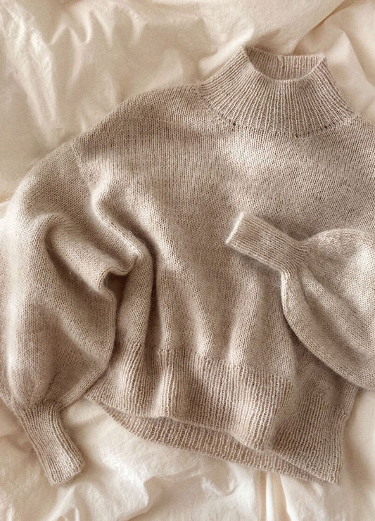 Soft beige Balloon Sweater in fuzzy knit with oversized fit and tapered cuffs, styled with jeans.