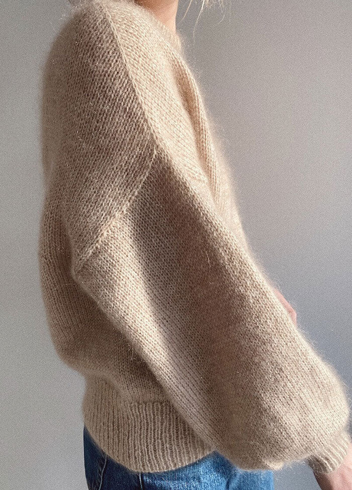 Loose beige Balloon Sweater made from cozy textured yarn, featuring voluminous sleeves and fitted cuffs.