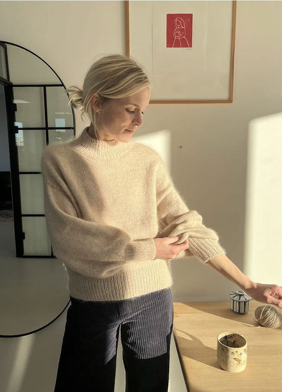 Oversized beige Balloon Sweater with soft balloon sleeves and tapered cuffs, worn casually with denim.