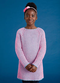 Young girl in a pink and blue striped sweater stands against a blue background, smiling softly. She wears a pink headband, projecting a calm and cheerful vibe.