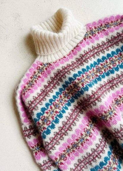 Colourful knitted sweater with a cozy cream turtleneck. Features vibrant stripes of pink, teal, and brown on a textured pattern. Warm, inviting feel.
