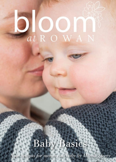 A mother lovingly holds her baby, who is wearing a chunky knit sweater with gray stripes. The cover text reads "bloom at Rowan - Baby Basics."