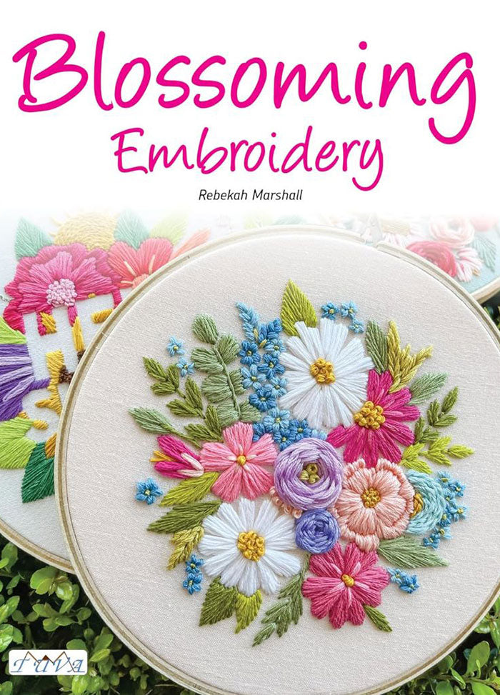 Cover of Blossoming Embroidery, featuring a vibrant arrangement of embroidered floral designs, including wildflower bouquets, birds, and butterflies, all rendered in bright, blooming color palettes. The title is displayed in bold white letters against a soft pink background.