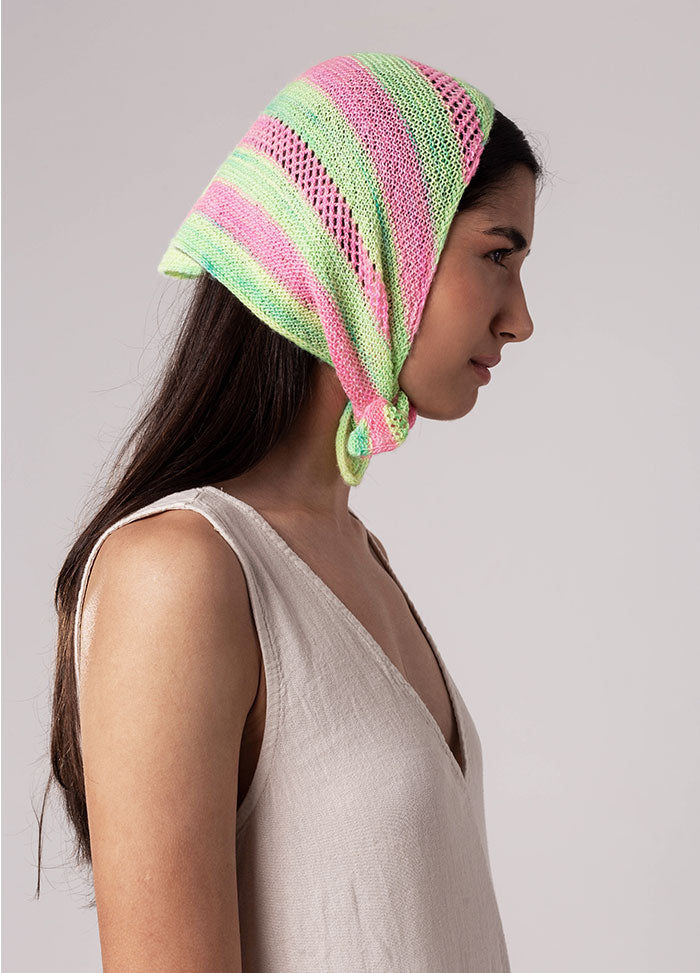 Person wearing Chalcito Scarf with pink, green, and light blue stripes, tied under the chin over sleeveless beige top.