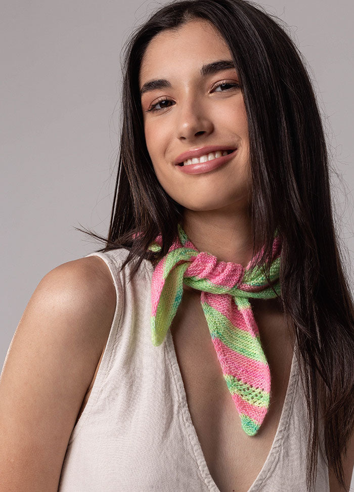 Person wearing Chalcito Scarf with pink and green stripes, tied around neck with ends hanging down, over sleeveless light-colored top.