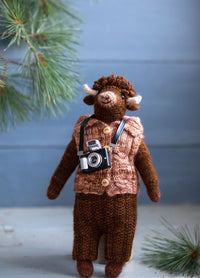 Forrest the Bison: knitted bison in a brown vest with buttons, wearing a small black camera around its neck.