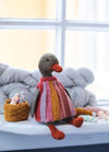 Nanna the Lady Duck: knitted duck in a striped dress, seated near yarn skeins and a basket of colorful yarn balls.