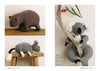 Three knitted stuffed animals: a brown wombat, a gray mouse with a fluffy tail, and a cuddly koala holding a branch. Playful and cozy tone.