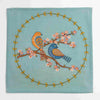 Decorative fabric panel with birds and floral design on a teal background