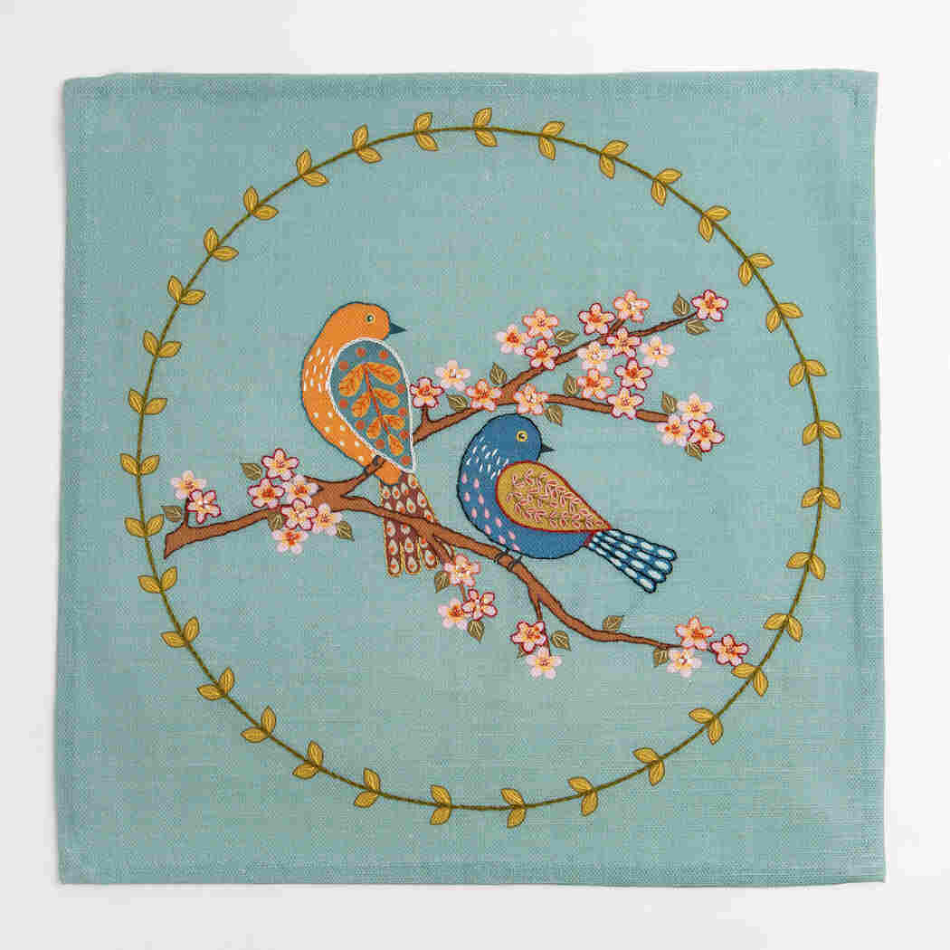 Decorative fabric panel with birds and floral design on a teal background