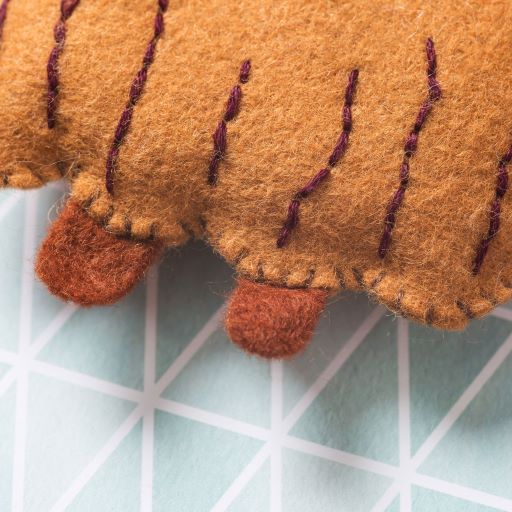 Close-up of a felt reindeer toy on a grid background