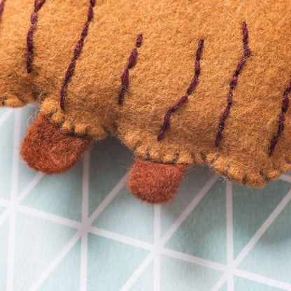 Close-up of a felt reindeer toy on a grid background