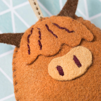 Close-up of a brown plush reindeer toy with a blurred light blue background