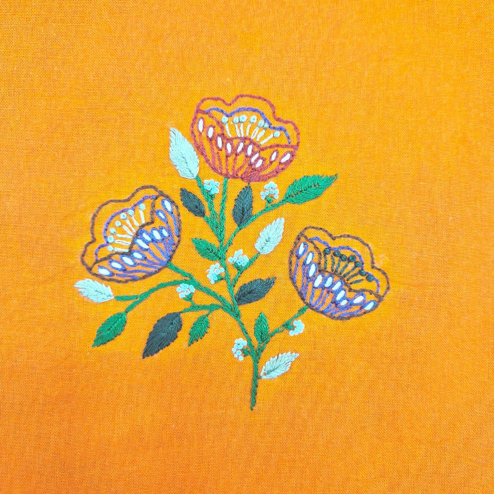 Embroidered floral design on a yellow fabric background