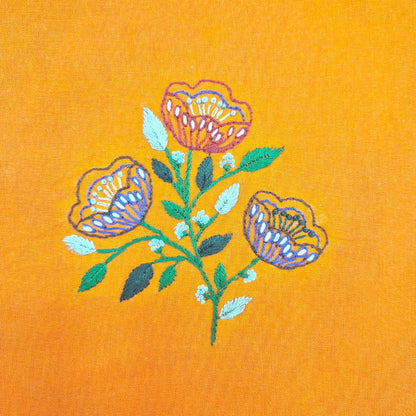 Embroidered floral design on a yellow fabric background