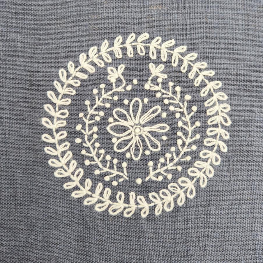 Decorative white floral pattern on a gray fabric background