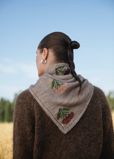 Embroidered Achillea Scarf': Light gray scarf with embroidered berries and leaves in red, pink, and purple, worn with a brown sweater.