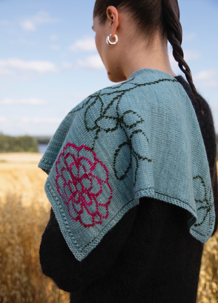 Rose Scarf': Light blue scarf with green vine embroidery and a prominent pink rose, worn outdoors with greenery in the background.