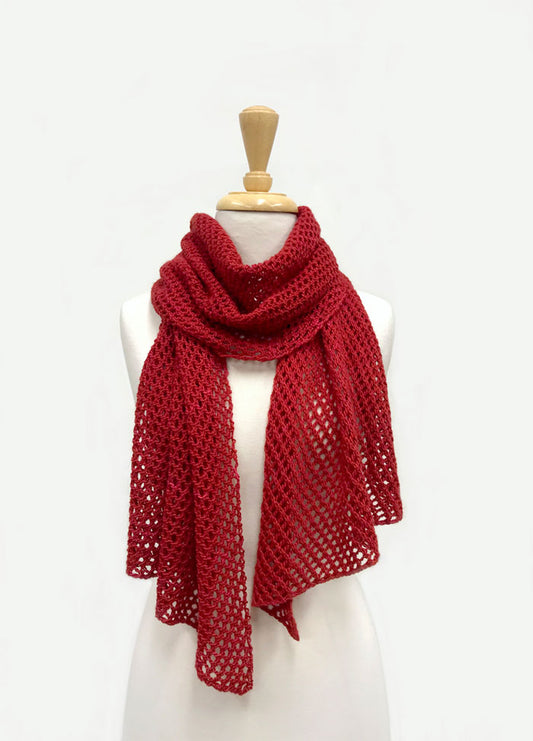 Easy 4 Ply Lace Scarf in red, featuring a delicate openwork pattern, draped around a mannequin’s neck with both ends hanging down.