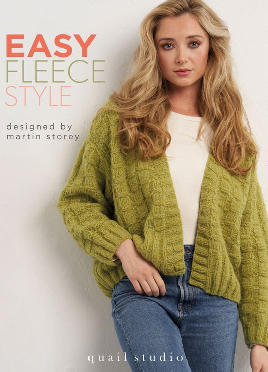 A woman in a light green knitted cardigan and jeans poses confidently against a white wall. Text above reads, "Easy Fleece Style, designed by Martin Storey." The mood is cozy and stylish.