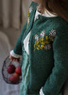 Aster: floral embroidery on green knit cardigan, featuring delicate blooms across the chest.