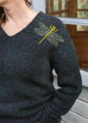 Dragonfly: yellow and green dragonfly embroidered on shoulder of dark knit sweater.