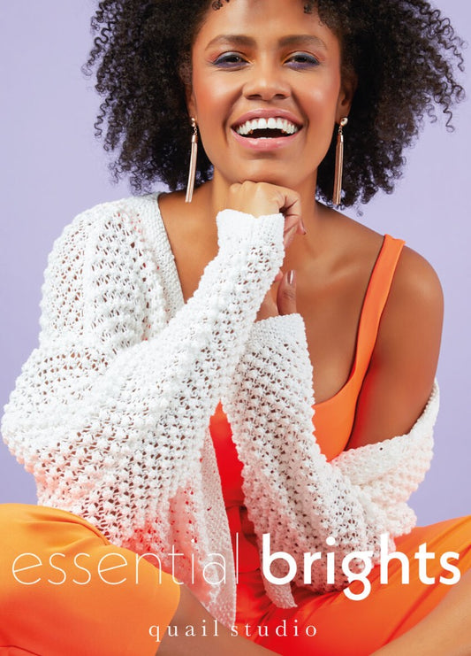 A smiling woman with curly hair wears a white knit cardigan over an orange top against a light purple background. Text reads "essential brights."