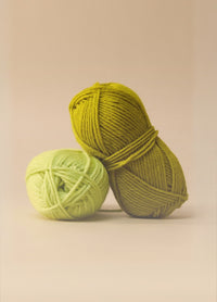 Two colourful balls of machine washable wool yarn displayed on a beige background, highlighting their 10ply weight and care instructions.