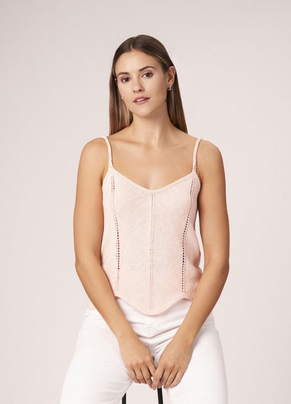 Loose-fitting summer top with textured stitch pattern, worn with relaxed trousers.