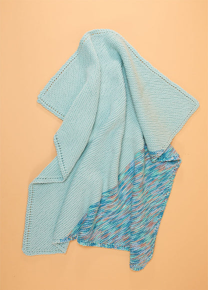 Light blue Florence Blanket with a lower section in pink, blue, and white pattern, finished with a textured knit border.
