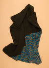 Florence Blanket with a solid black section and a contrasting multicolored panel in blue, yellow, and gray.