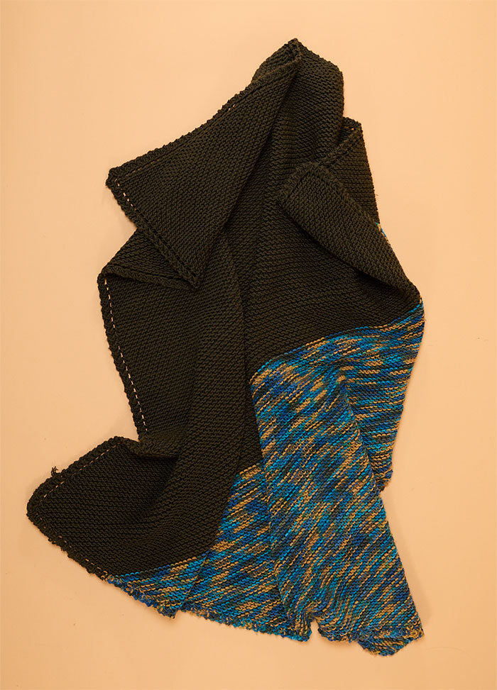 Florence Blanket with a solid black section and a contrasting multicolored panel in blue, yellow, and gray.