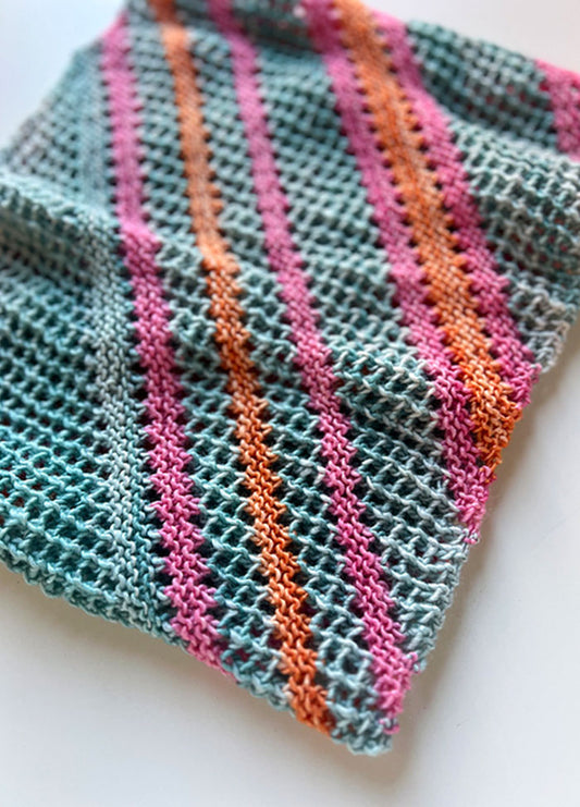 Friends and Family Cowl, hand-knit with diagonal stripes in teal, pink, and orange on a mesh-like, airy texture.