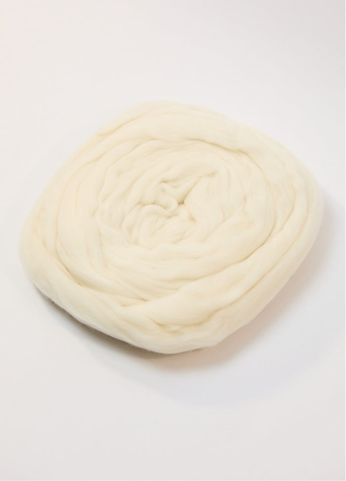 A white ball of Australian roving yarn on a white background, highlighting its fine Merino fibers and soft appearance.