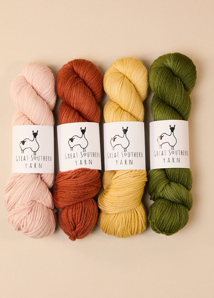 Four skeins of hand-dyed Australian merino yarn in various colors, ideal for DK weight projects.